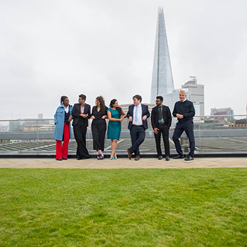 Image of 3 business people talking on London office building veranda